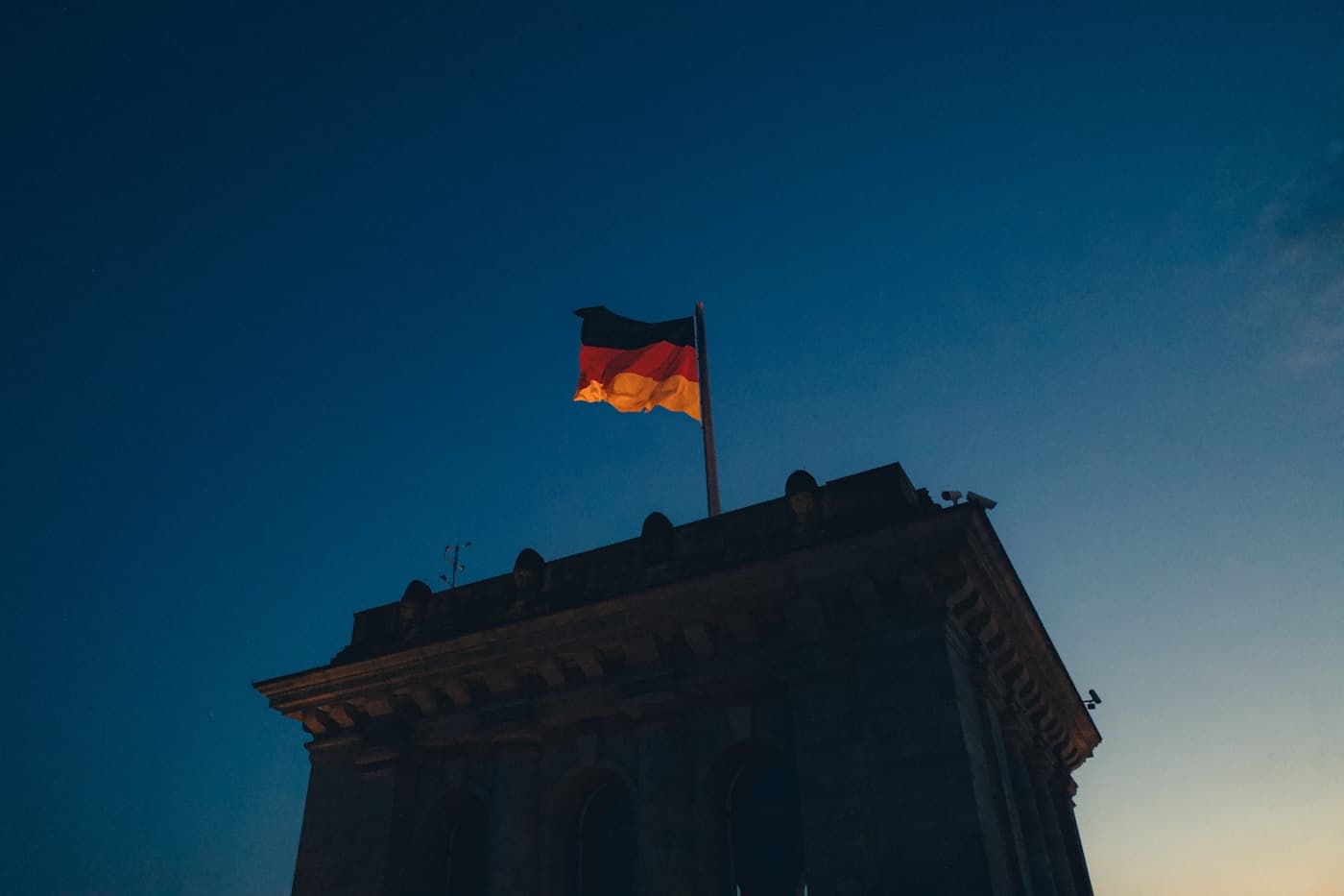 German flag flying above the Reichstag building in Berlin