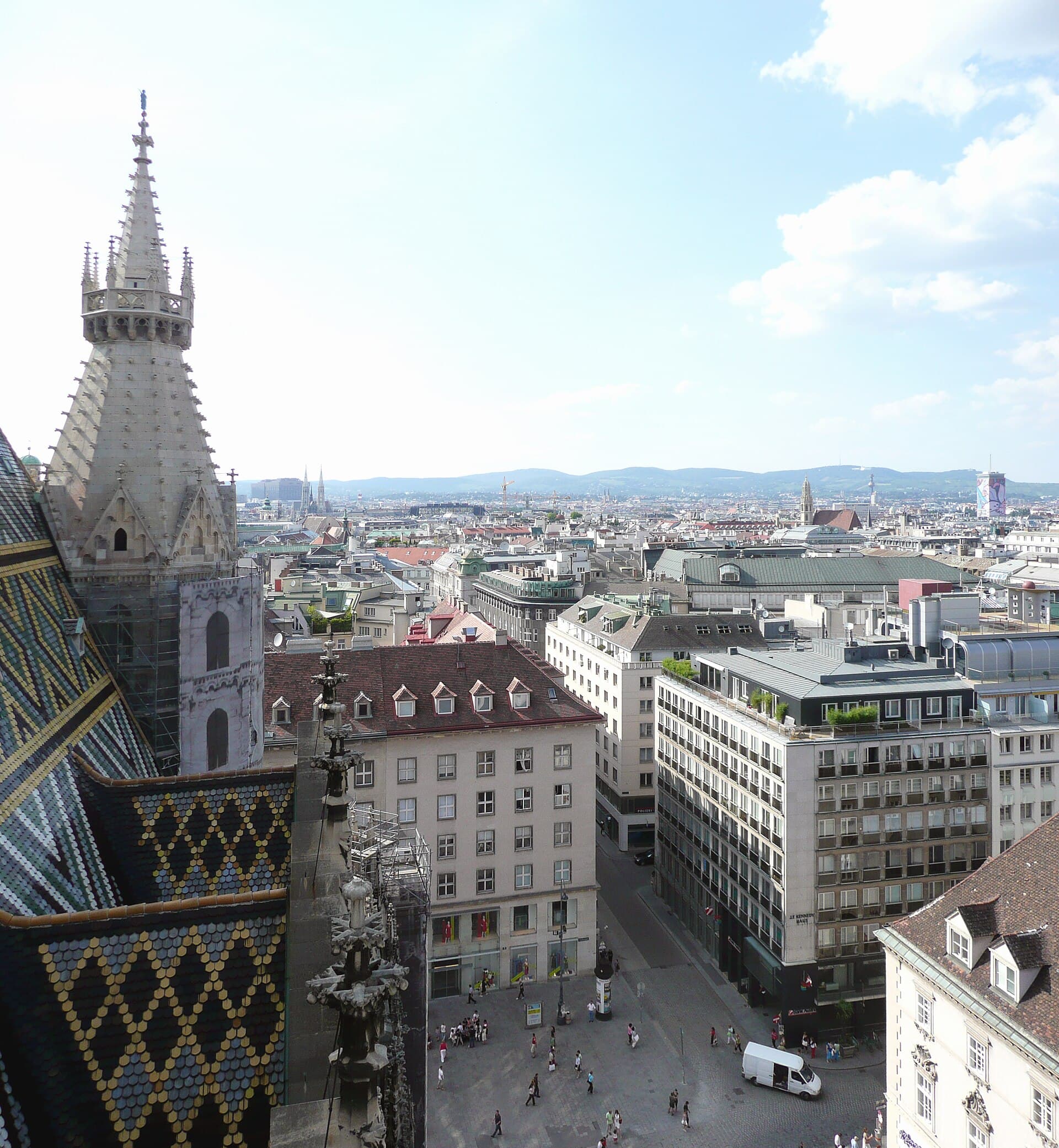 Stephansdom tiled roof and Stephansplatz from the cathedral tower, Vienna rooftops stretching to the hills